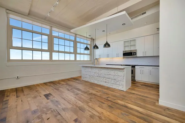 a view of kitchen with wooden floor and electronic appliances
