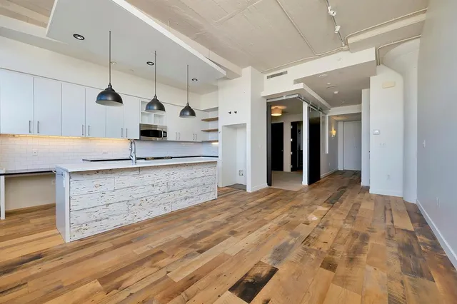 a kitchen with kitchen island a sink stainless steel appliances and cabinets