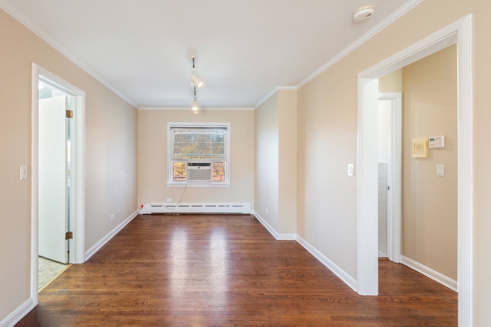 2252 Sherman Avenue, Unit 2 Evanston, IL 60201 - Photo 13 of 24 a view of an empty room with wooden floor and a window