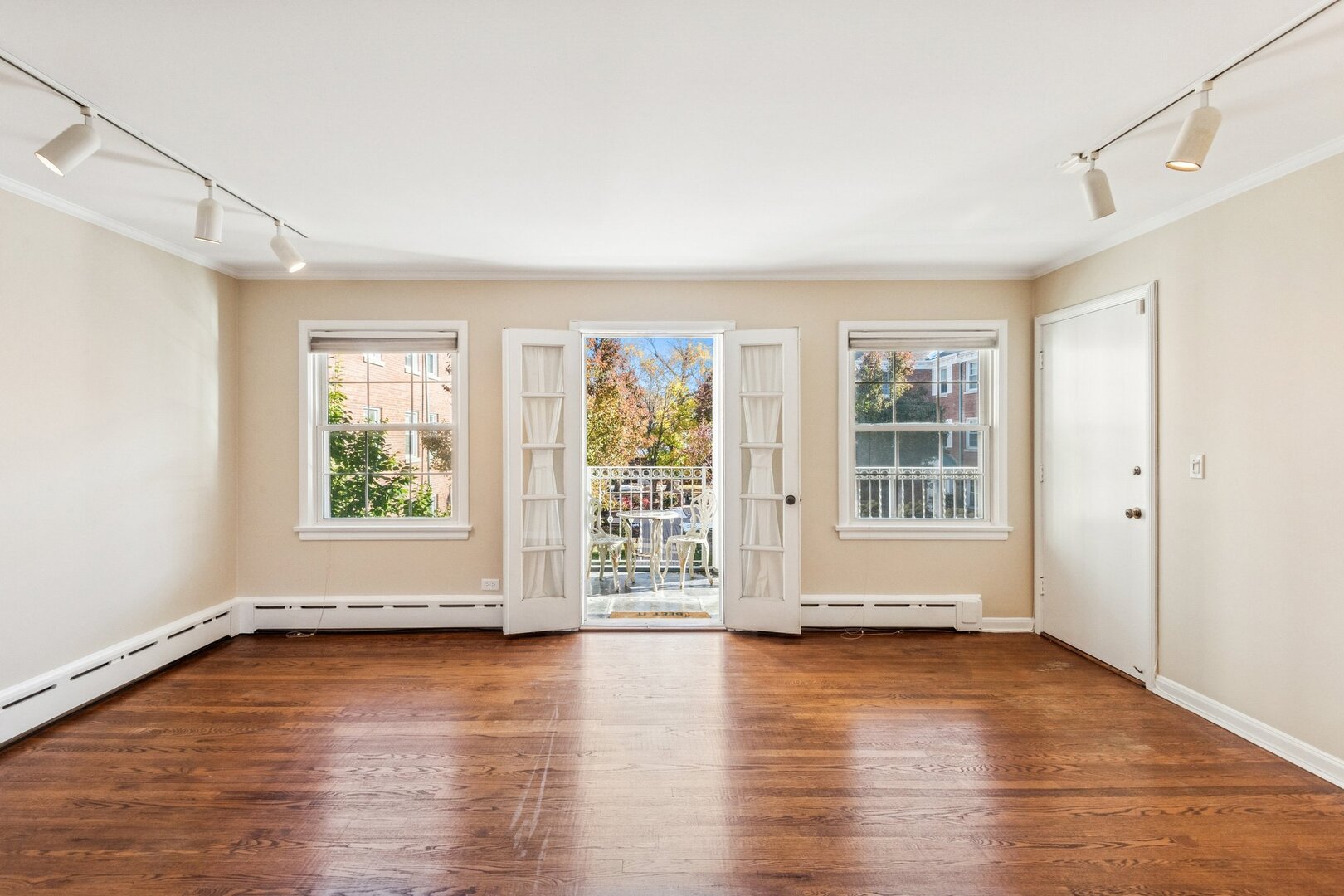 2252 Sherman Avenue, Unit 2 Evanston, IL 60201 - Photo 4 of 24 an empty room with wooden floor and windows with curtains