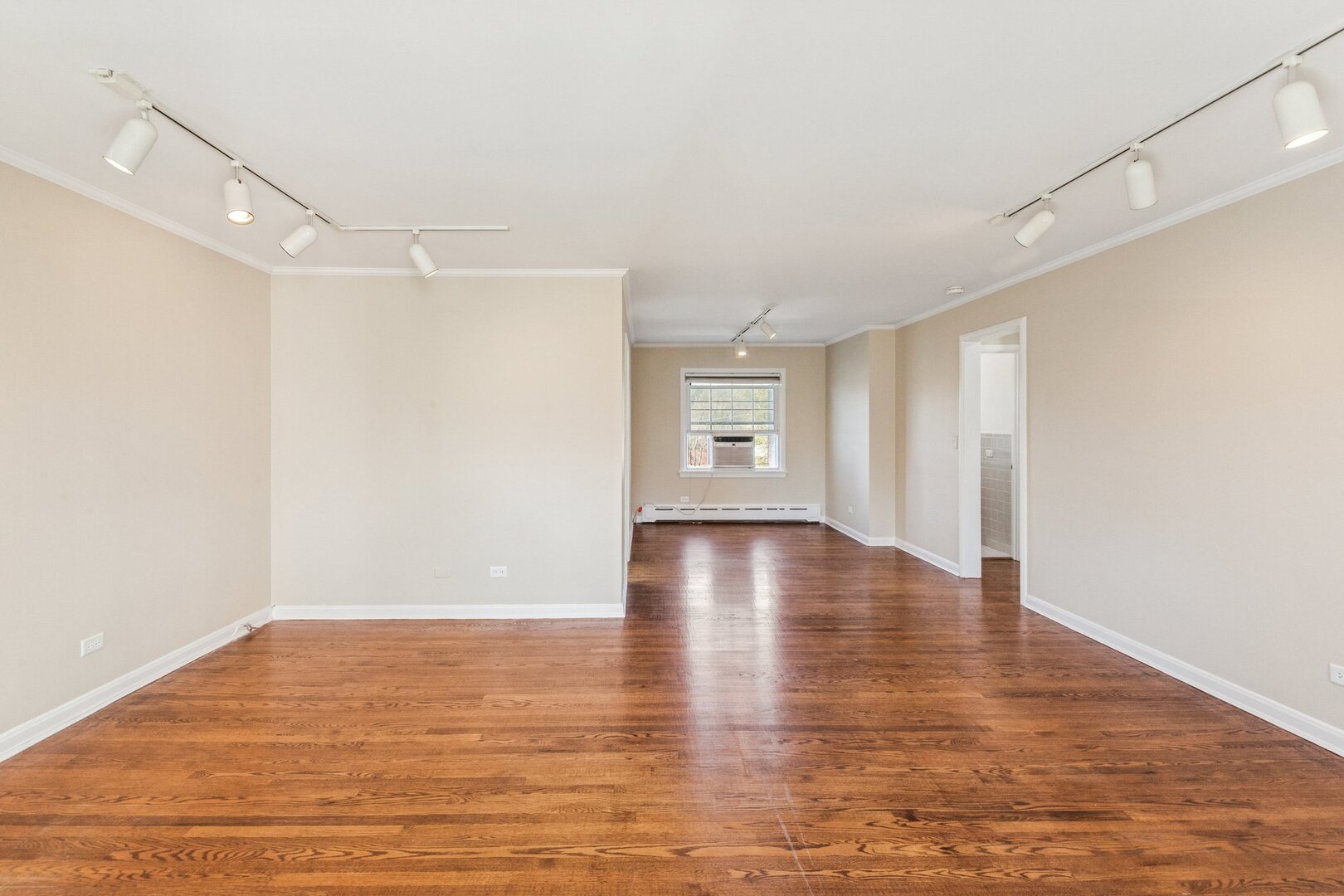 2252 Sherman Avenue, Unit 2 Evanston, IL 60201 - Photo 10 of 24 a view of an empty room with wooden floor and a window