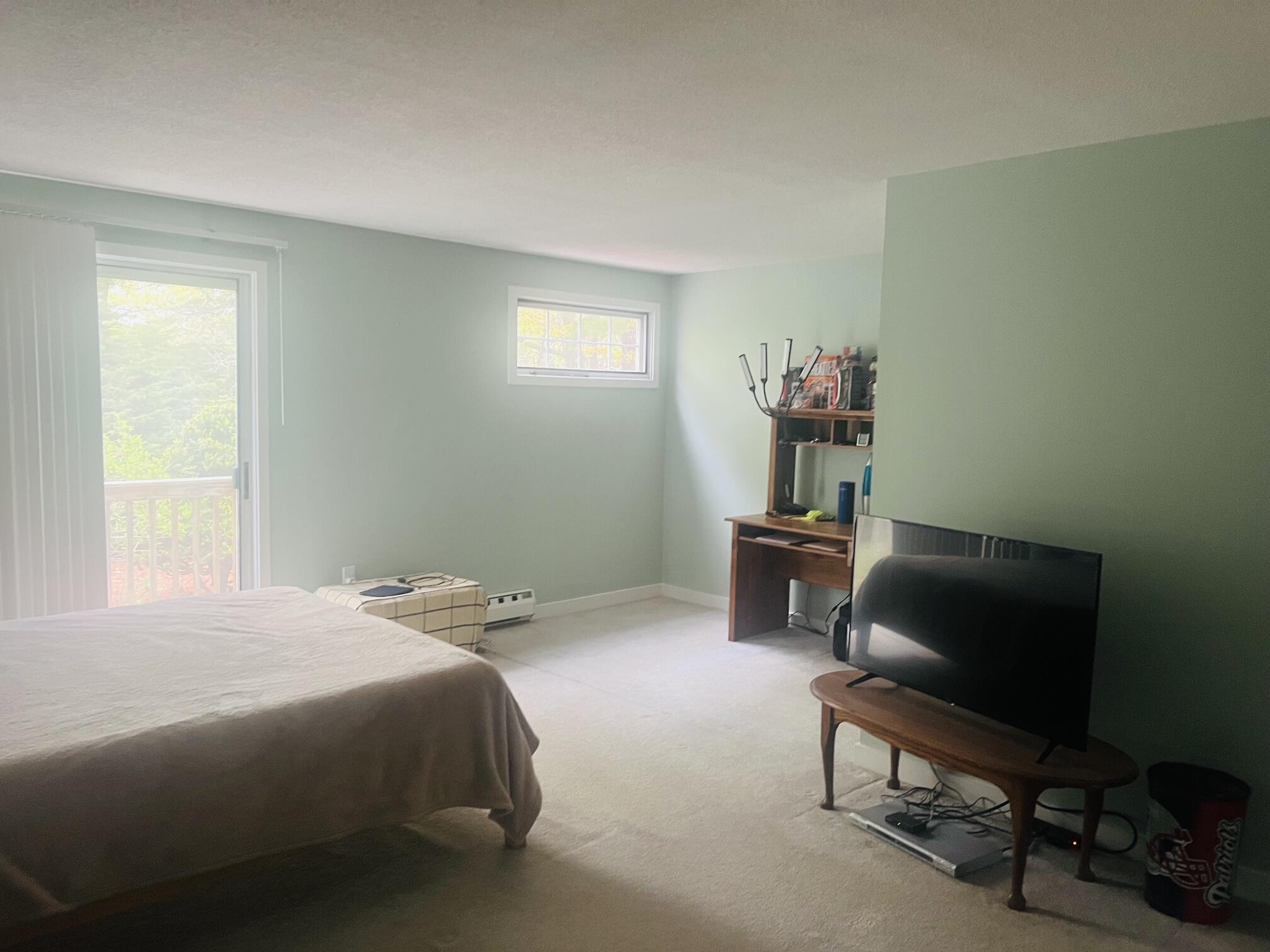 1431 Iyannough Road, Unit 1 Centerville, MA 02632 - Photo 16 of 28 a bedroom with a bed and a chair in it