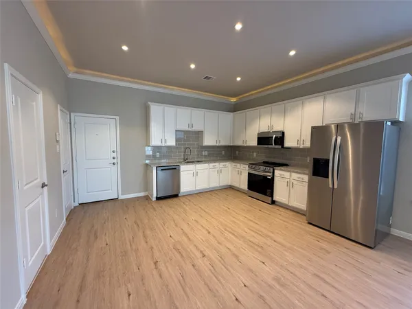 a kitchen with stainless steel appliances granite countertop a refrigerator and a stove top oven