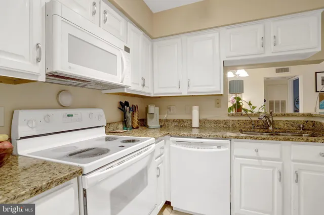 a bathroom with a granite countertop sink mirror vanity and toilet