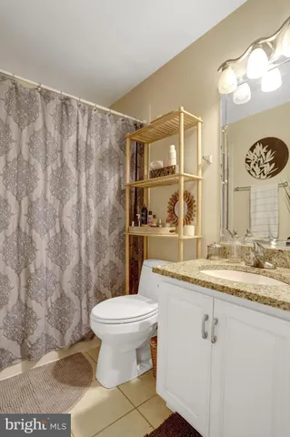 a bathroom with a granite countertop sink mirror vanity and toilet