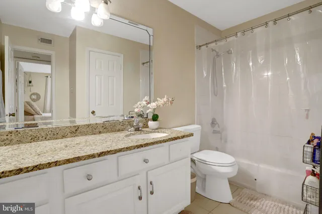 a bathroom with a granite countertop sink a toilet and a shower