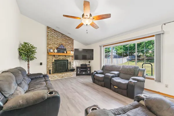 a living room with furniture a fireplace and a chandelier