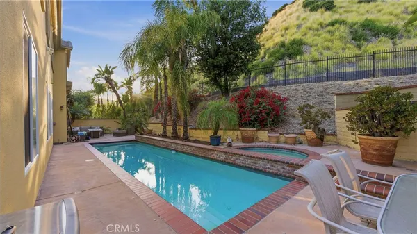 a view of a swimming pool with a patio and a yard