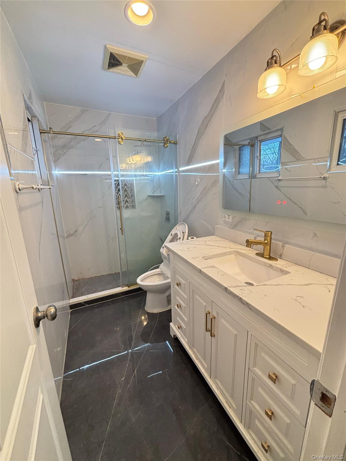 105 Seaman Road Jericho, NY 11753 - Photo 10 of 22 a bathroom with a granite countertop sink a mirror and a shower
