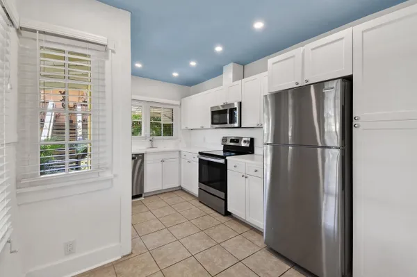 a kitchen with cabinets stainless steel appliances and window