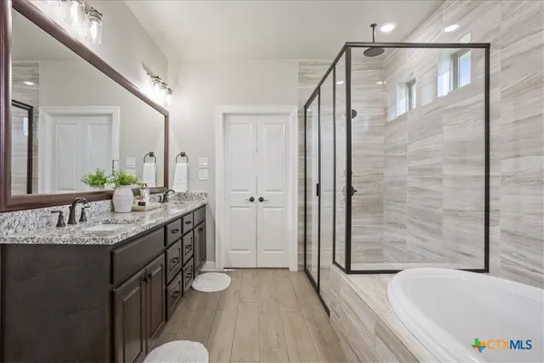 a bathroom with a granite countertop sink a toilet a mirror and shower