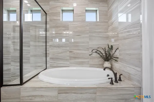 a bathroom with bathtub and shower