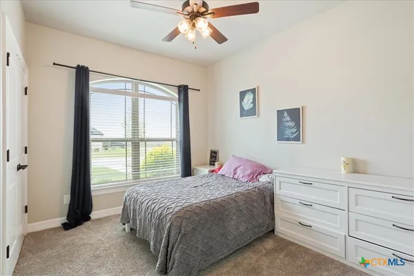 a bedroom with a large bed and a window
