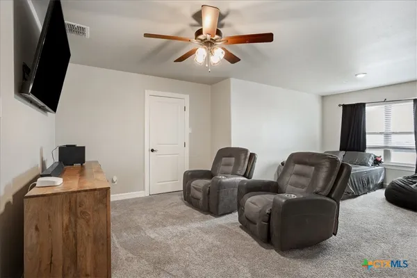a living room with furniture a flat screen tv and a window