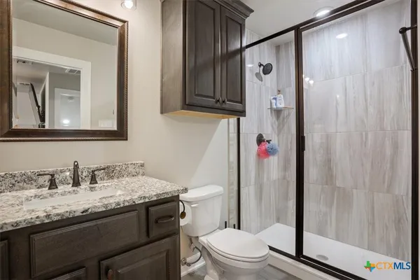 a bathroom with a granite countertop sink toilet and shower