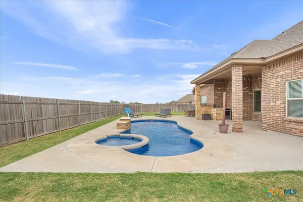 a view of a house with backyard and sitting area