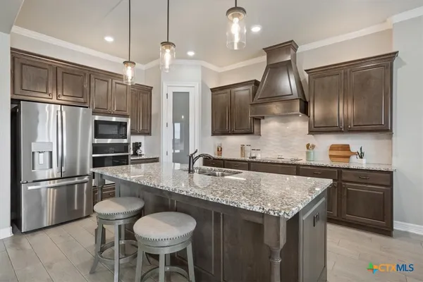 a kitchen with stainless steel appliances granite countertop a sink refrigerator and microwave