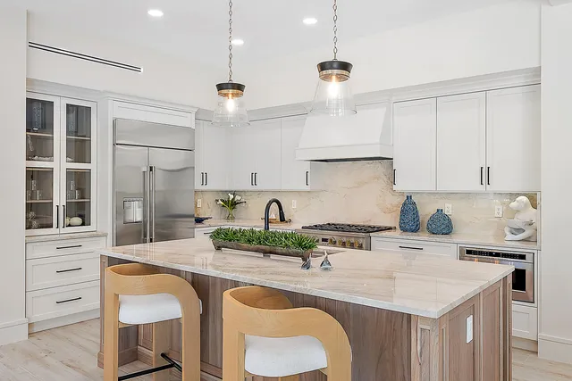 a living room with furniture kitchen view and a potted plant