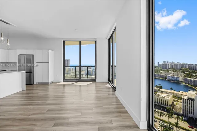 a view of a hallway with wooden floor and a bathroom