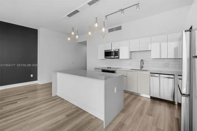 a view of a living room with a floor to ceiling window and kitchen