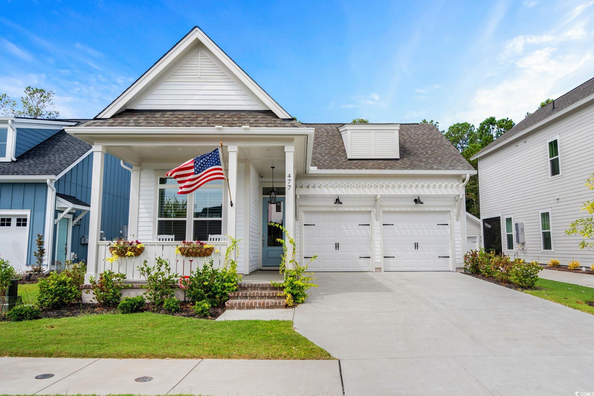 View of front facade with roof with shingles, an attached garage, driveway, and a front yard