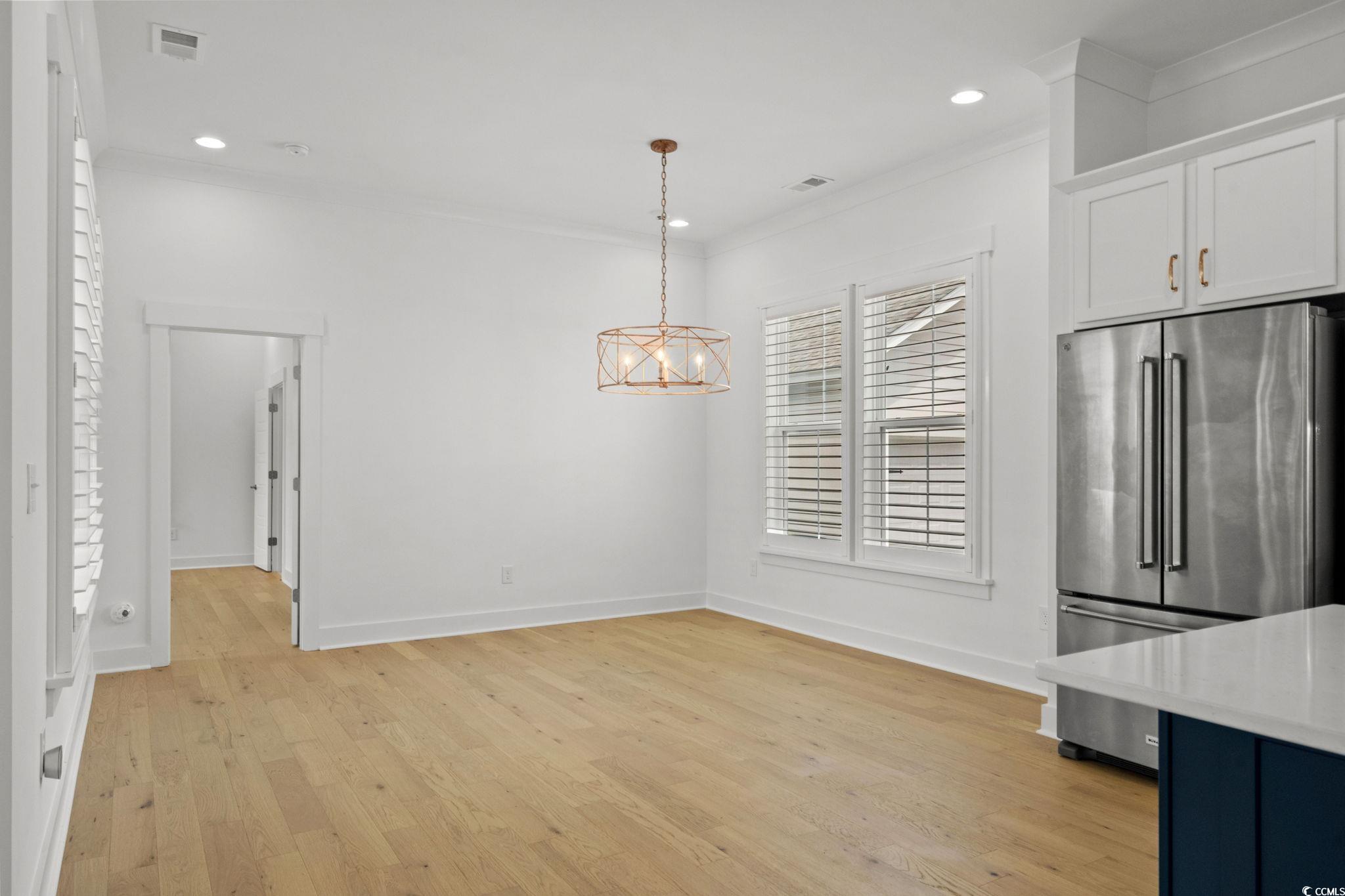 477 Ayrhill Loop Myrtle Beach, SC 29588 - Photo 9 of 39 Unfurnished dining area featuring light wood-type flooring, crown molding, recessed lighting, and a chandelier