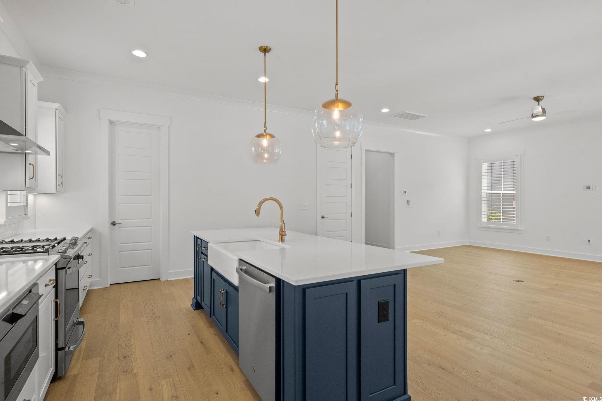 477 Ayrhill Loop Myrtle Beach, SC 29588 - Photo 12 of 39 Kitchen with white cabinetry, blue cabinetry, hanging light fixtures, recessed lighting, and stainless steel appliances