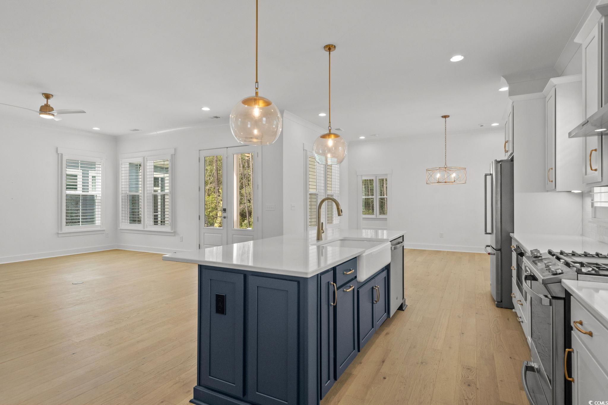477 Ayrhill Loop Myrtle Beach, SC 29588 - Photo 39 of 39 Kitchen featuring open floor plan, hanging light fixtures, light wood-style floors, appliances with stainless steel finishes, and light stone countertops