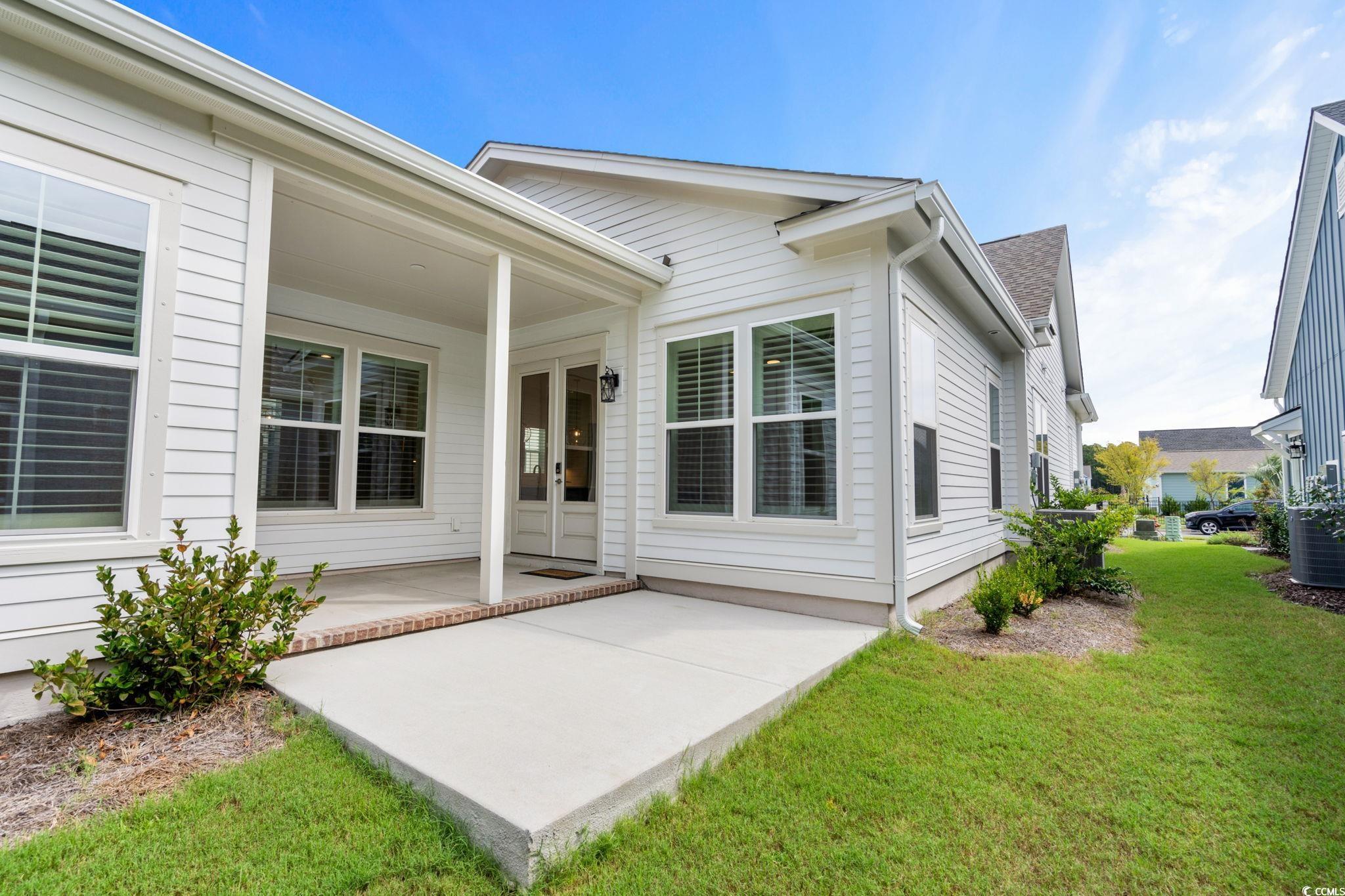 477 Ayrhill Loop Myrtle Beach, SC 29588 - Photo 17 of 39 Rear view of property featuring a patio area, a yard, and french doors