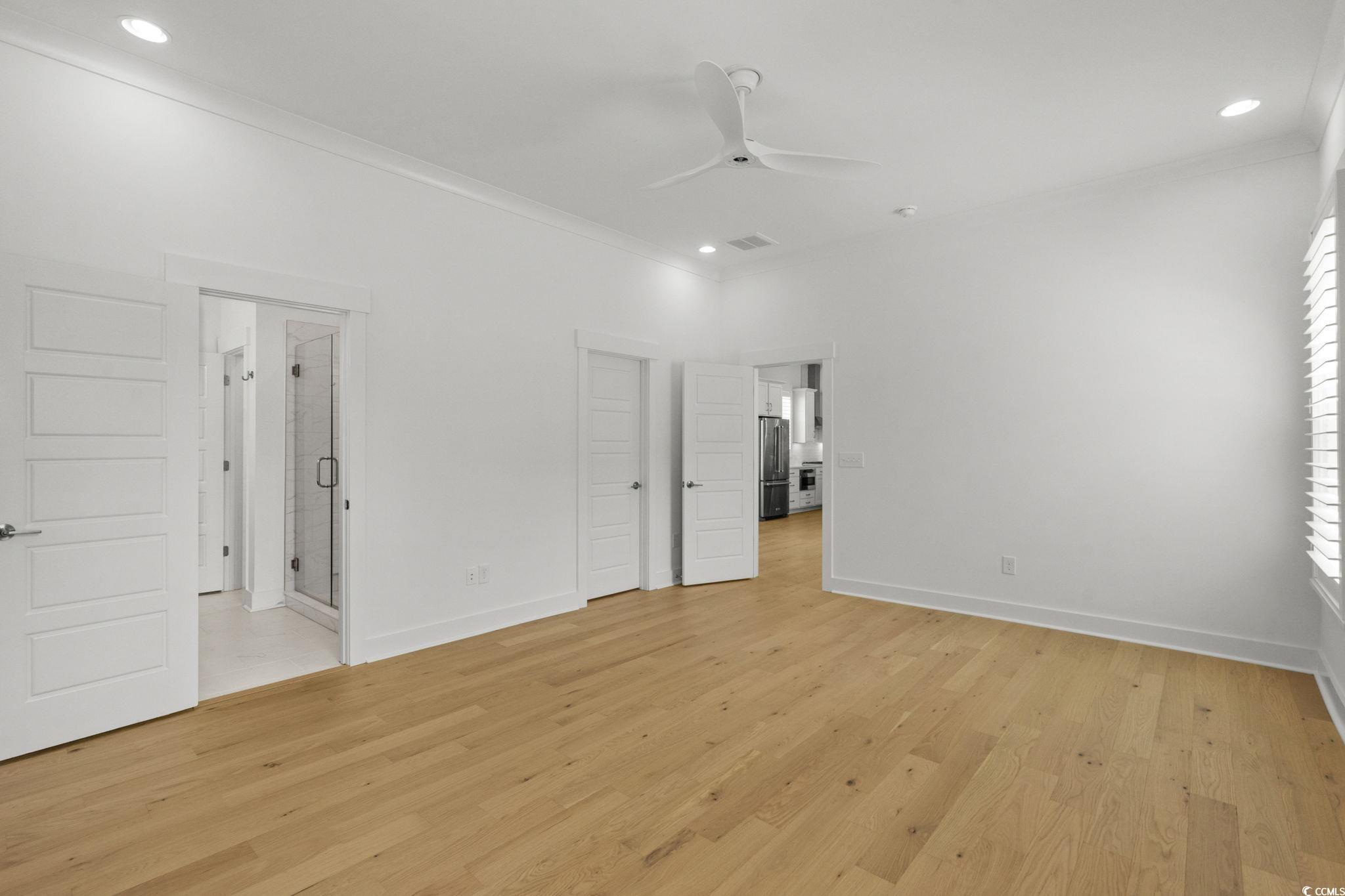 477 Ayrhill Loop Myrtle Beach, SC 29588 - Photo 21 of 39 Unfurnished bedroom with light wood-type flooring, recessed lighting, crown molding, high end fridge, and connected bathroom
