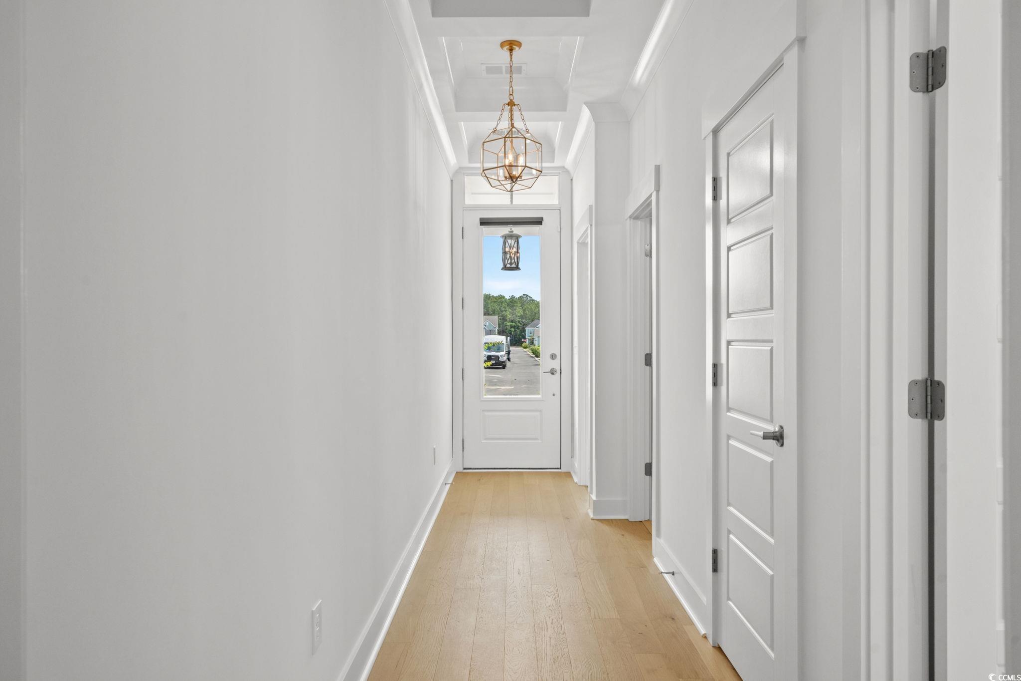 477 Ayrhill Loop Myrtle Beach, SC 29588 - Photo 4 of 39 Corridor with light wood-style floors and a chandelier