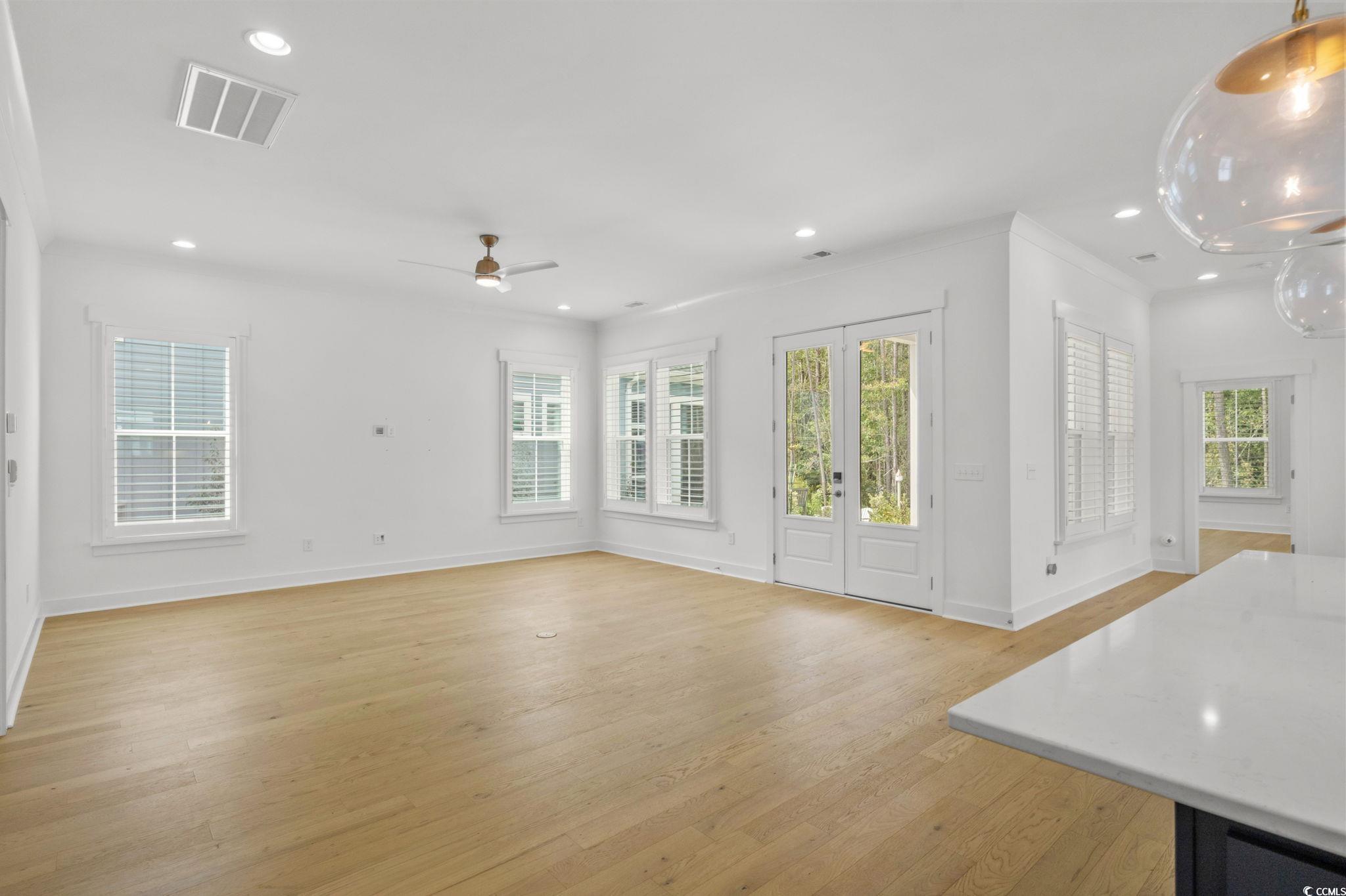 477 Ayrhill Loop Myrtle Beach, SC 29588 - Photo 6 of 39 Unfurnished living room featuring recessed lighting, light wood-style flooring, ceiling fan, crown molding, and french doors