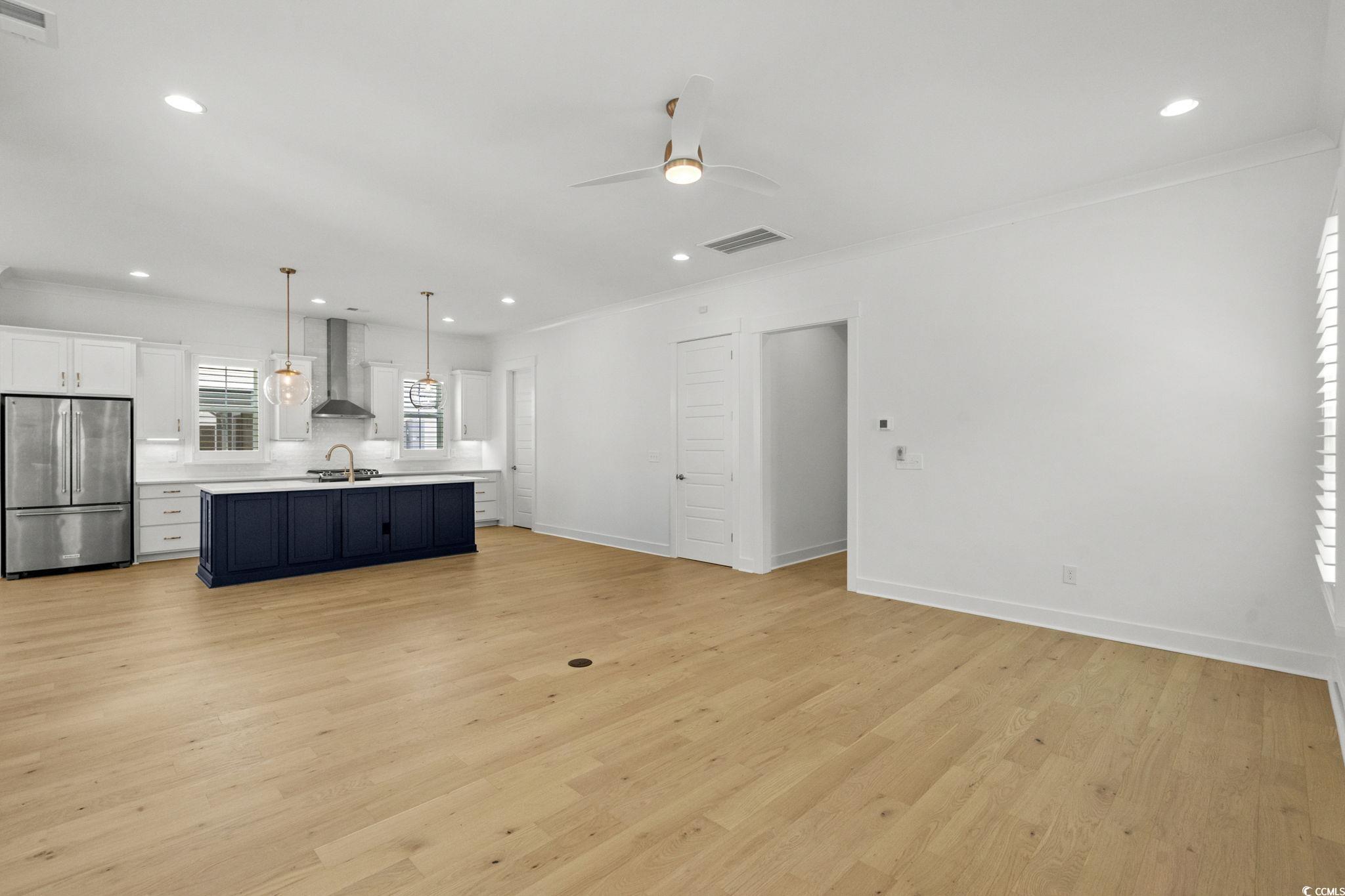 477 Ayrhill Loop Myrtle Beach, SC 29588 - Photo 37 of 39 Kitchen featuring white cabinetry, open floor plan, freestanding refrigerator, decorative light fixtures, and light countertops