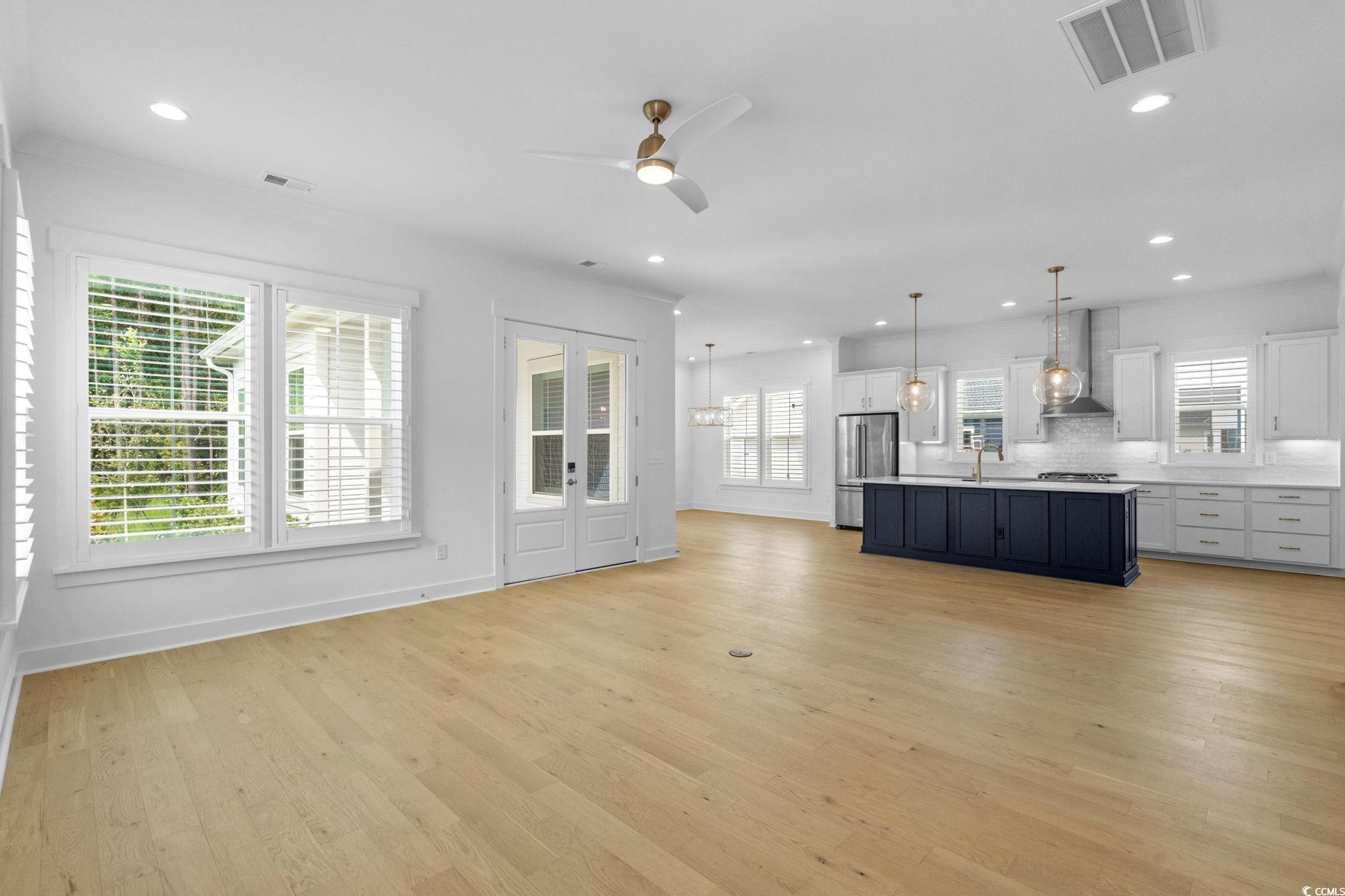 477 Ayrhill Loop Myrtle Beach, SC 29588 - Photo 38 of 39 Kitchen with white cabinets, open floor plan, pendant lighting, light countertops, and light wood finished floors