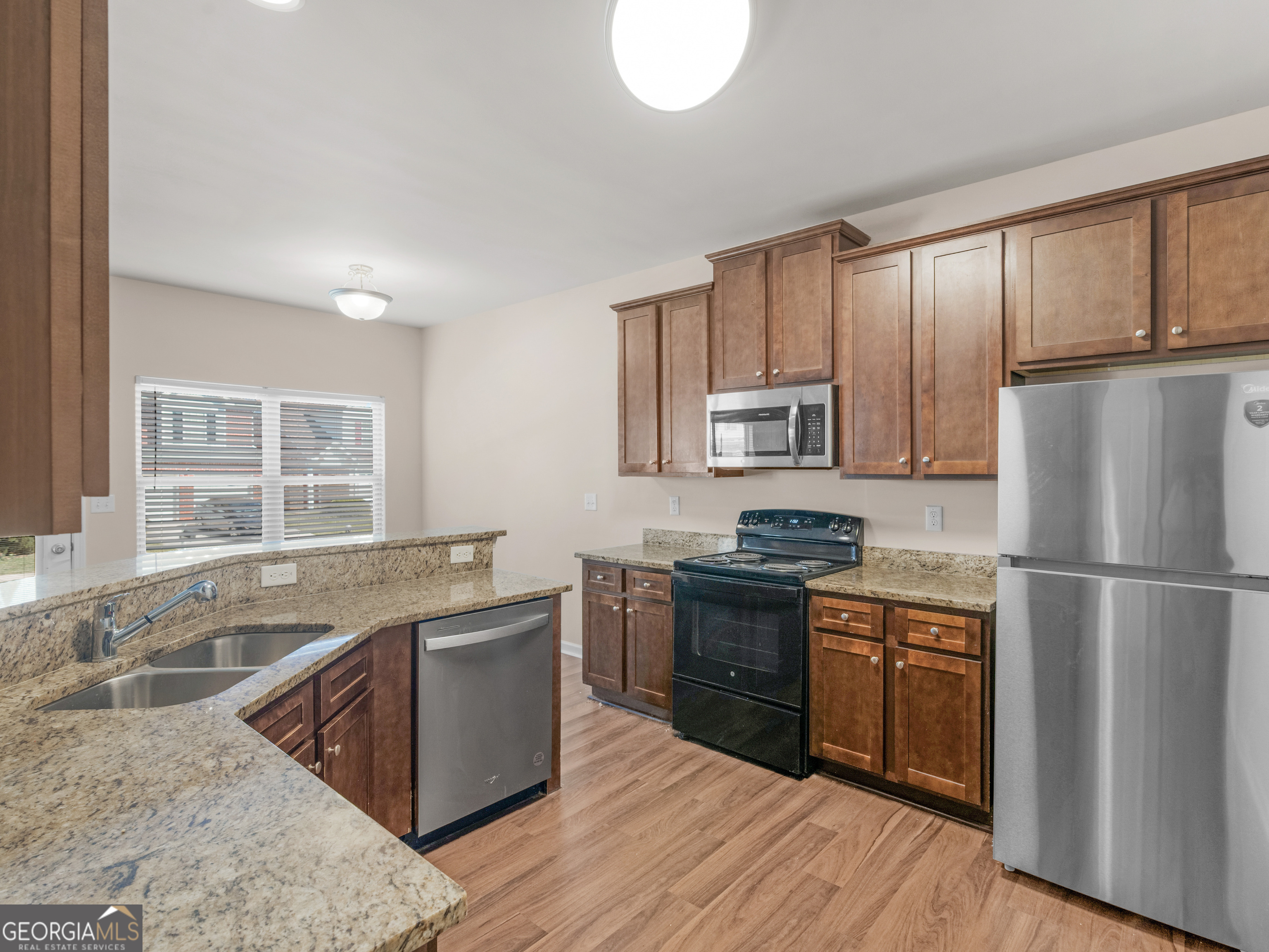 1244 Faye Court McDonough, GA 30253 - Photo 11 of 35 a kitchen with stainless steel appliances granite countertop a stove a sink dishwasher a refrigerator and white cabinets with wooden floor