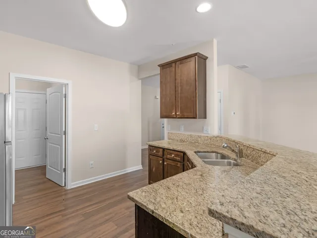 a kitchen with a sink a stove and wooden floor