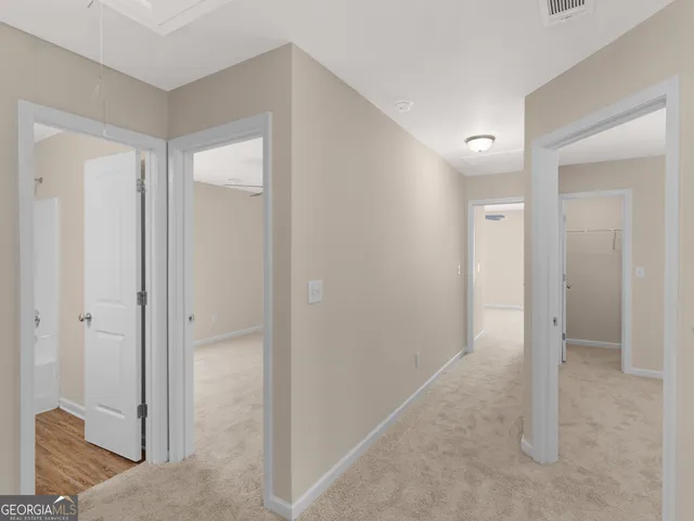 a view of a hallway with closet and bathroom
