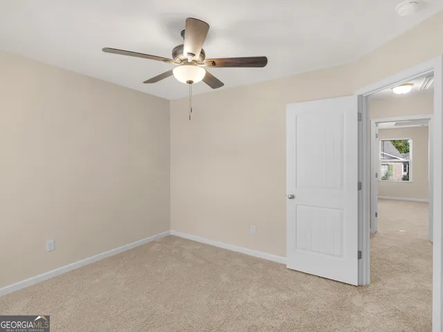 an empty room with a chandelier fan and closet