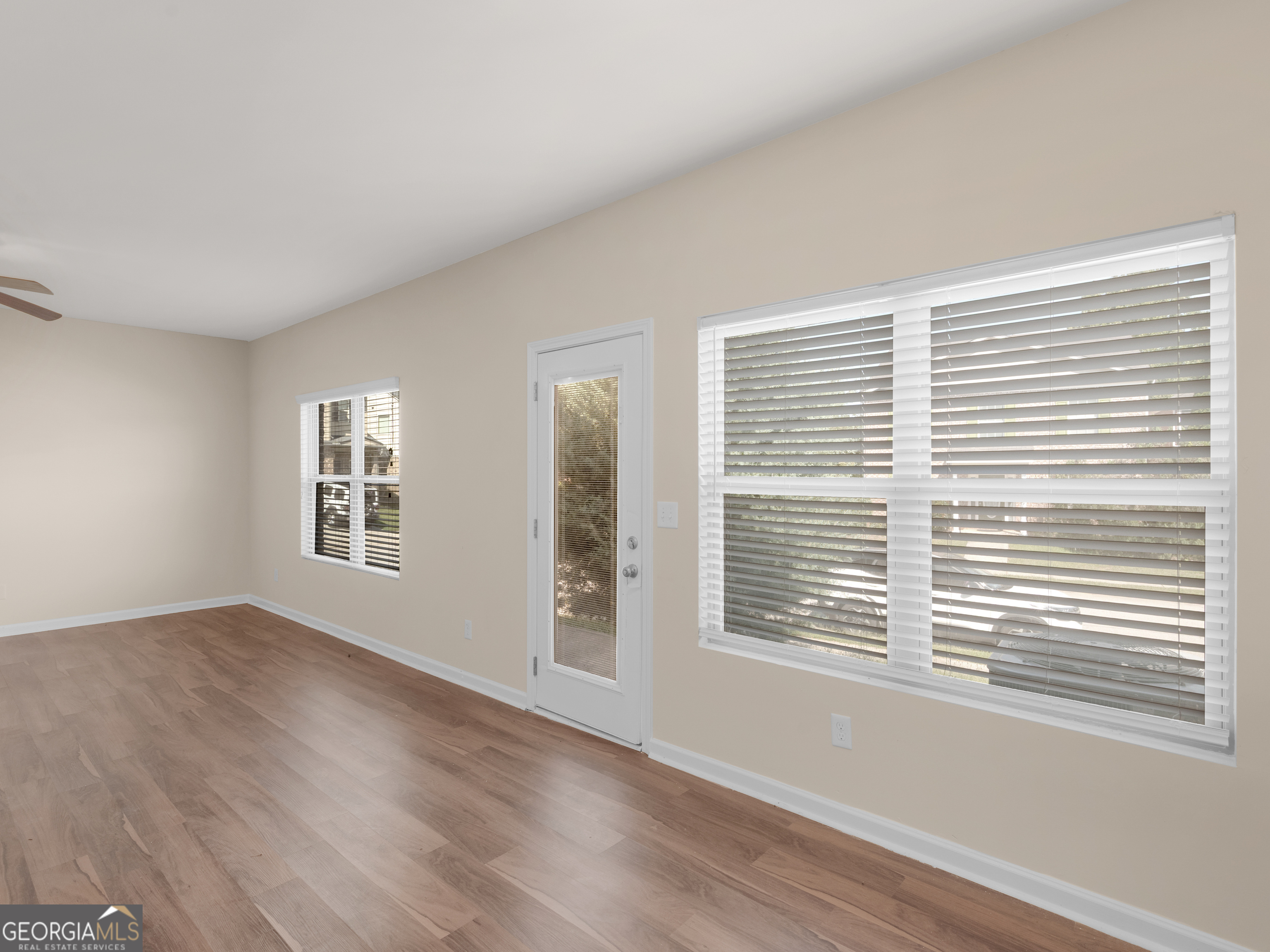 1244 Faye Court McDonough, GA 30253 - Photo 6 of 35 a view of an empty room with wooden floor and a window