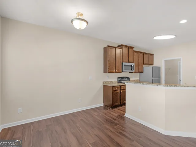 a kitchen with a refrigerator and a stove top oven
