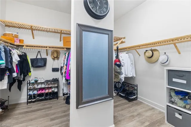 a view of walk in closet with clothes and shoes