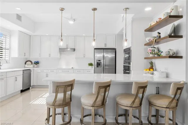 a kitchen with a dining table chairs sink and cabinets