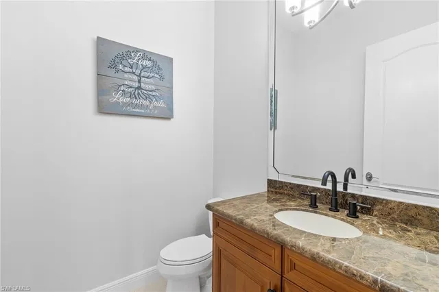 a bathroom with a granite countertop toilet sink and mirror