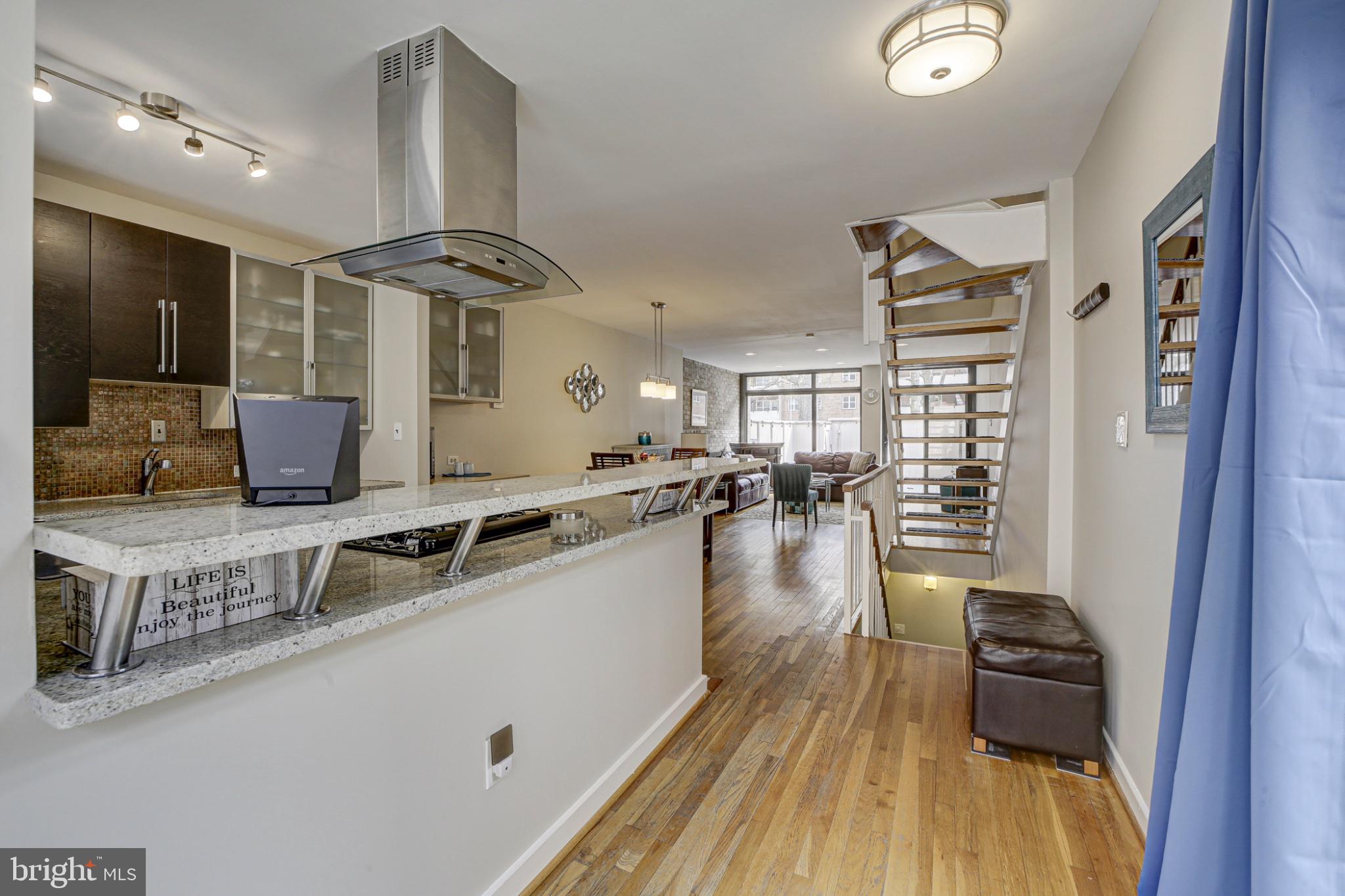 a kitchen with stainless steel appliances granite countertop a stove and a wooden floors