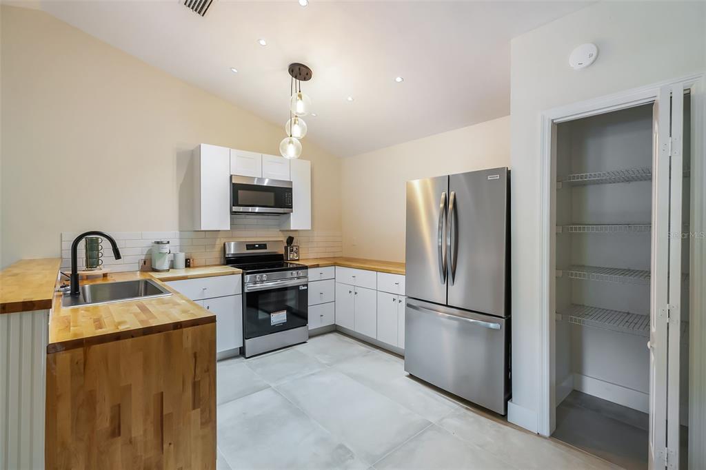 3222 Southwest 27th Street Gainesville, FL 32608 - Photo 11 of 42 a kitchen with stainless steel appliances granite countertop a refrigerator a stove a sink and a microwave
