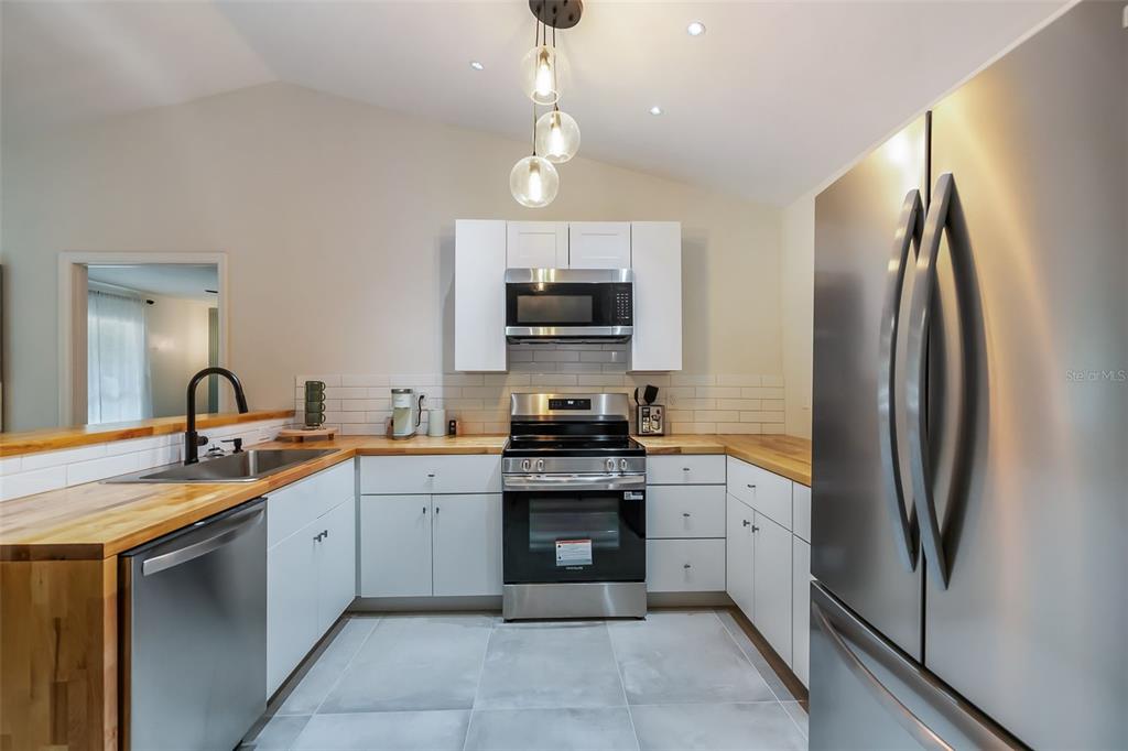 3222 Southwest 27th Street Gainesville, FL 32608 - Photo 12 of 42 a kitchen with stainless steel appliances granite countertop a refrigerator sink and cabinets