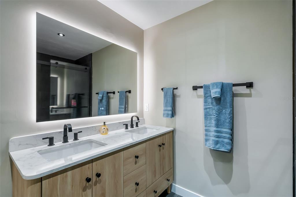 3222 Southwest 27th Street Gainesville, FL 32608 - Photo 22 of 42 a bathroom with a granite countertop sink a toilet a mirror and vanity