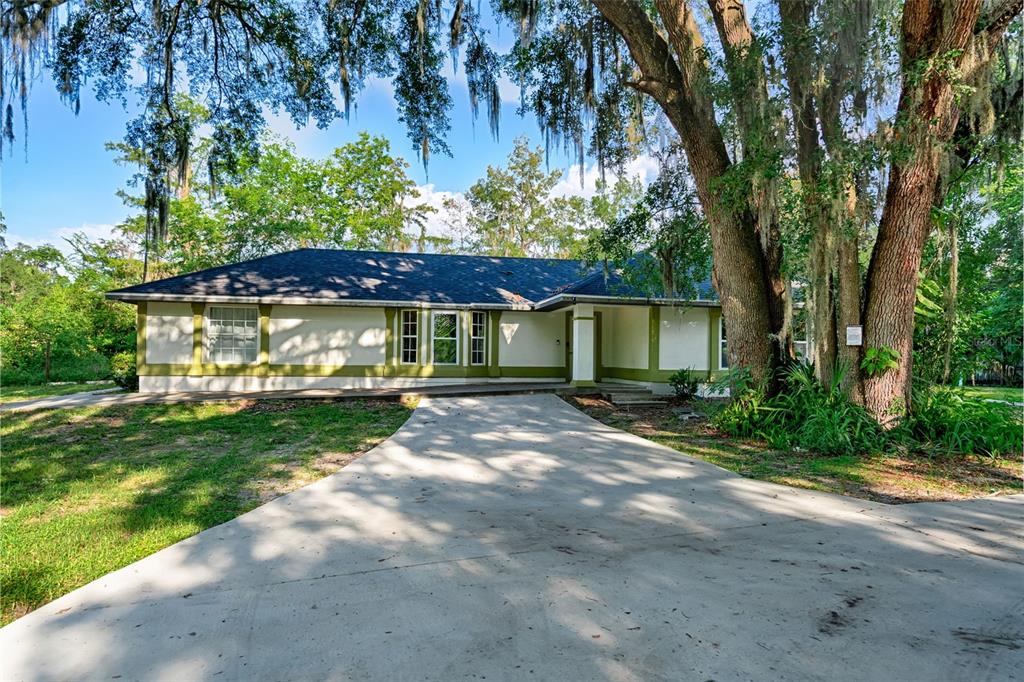 3222 Southwest 27th Street Gainesville, FL 32608 - Photo 34 of 42 a view of yellow house with a yard and large trees
