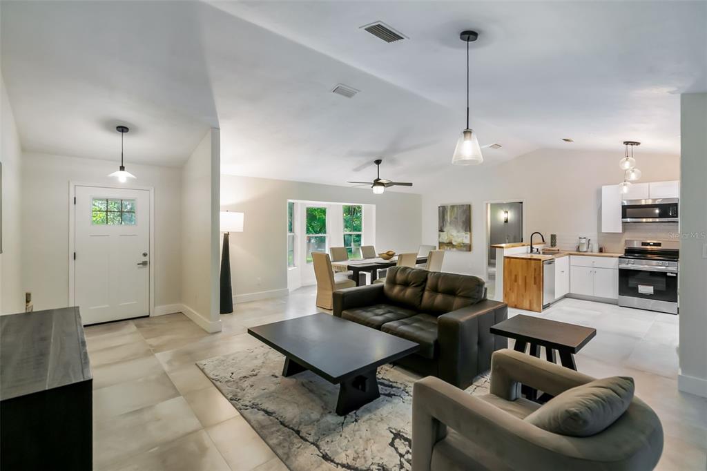3222 Southwest 27th Street Gainesville, FL 32608 - Photo 4 of 42 a living room with furniture kitchen view and a chandelier