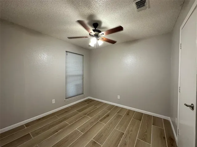 an empty room with closet and fan